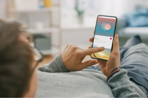 Persona usando el celular mientras consume contenido repetitivo en redes sociales